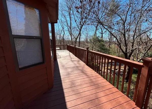 a balcony with wooden floor and trees