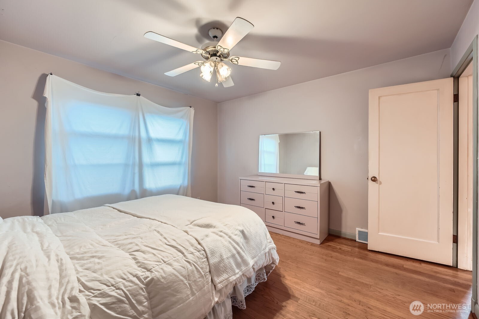 3041 52nd Avenue Southwest Seattle, WA 98116 - Photo 18 of 31 a bedroom with a bed and a chandelier