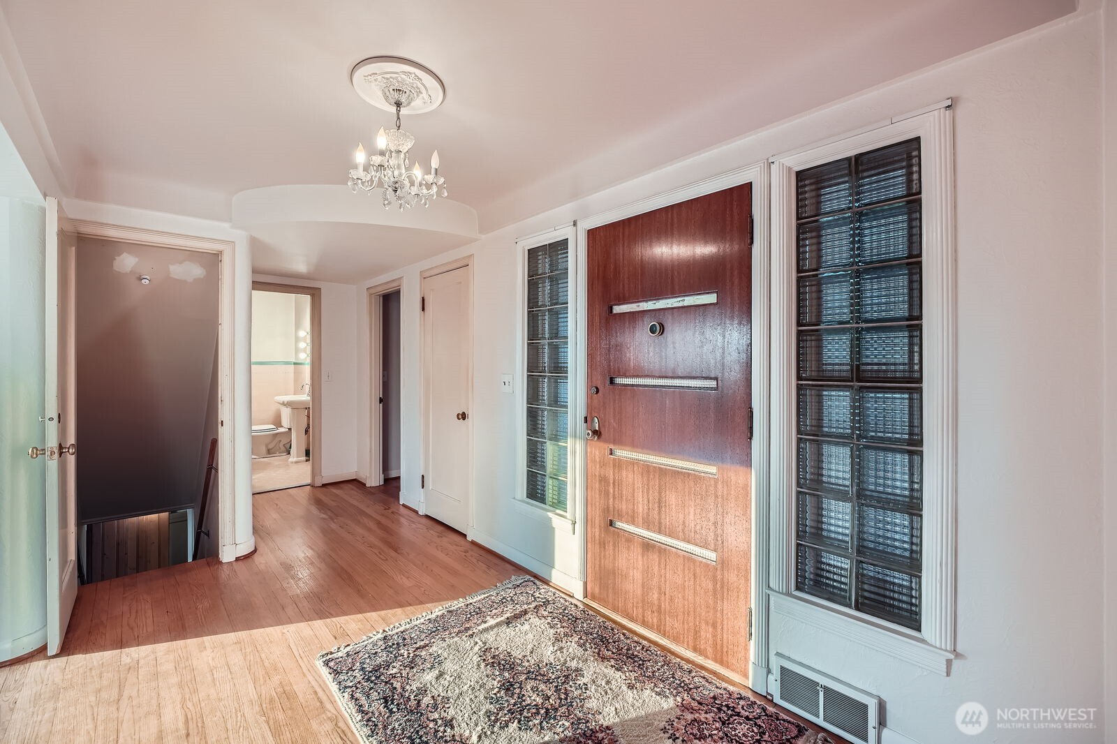 3041 52nd Avenue Southwest Seattle, WA 98116 - Photo 4 of 31 a bedroom with a bed and a chandelier