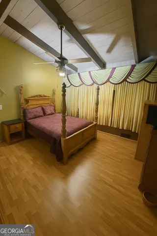 a bedroom with a bed and wooden floor