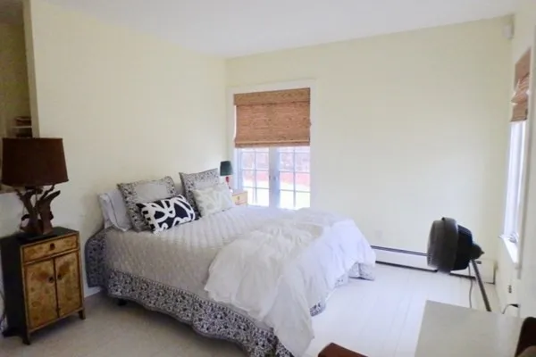 a bedroom with a bed tv and window