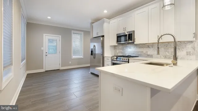 a kitchen with stainless steel appliances a microwave a sink and a refrigerator
