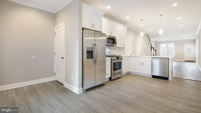 a kitchen with stainless steel appliances a refrigerator sink and cabinets
