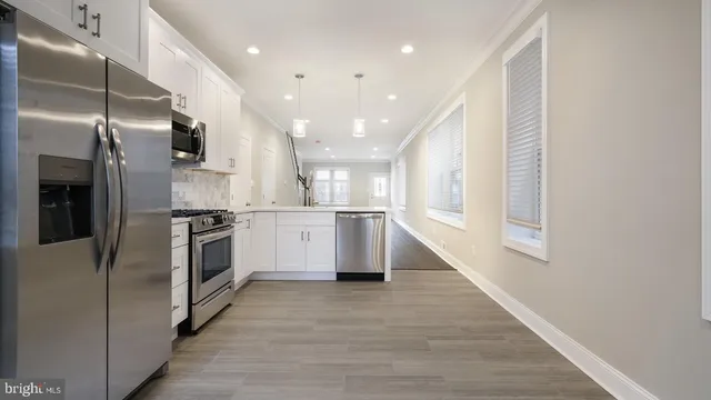 a kitchen with stainless steel appliances kitchen island granite countertop a refrigerator a sink and a stove