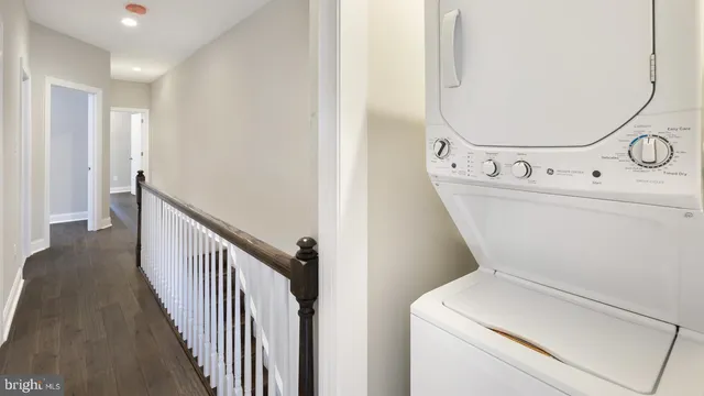 a view of washer and dryer with bathroom in the background