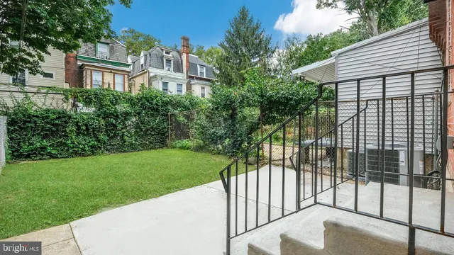 a view of a brick house with many windows and a yard