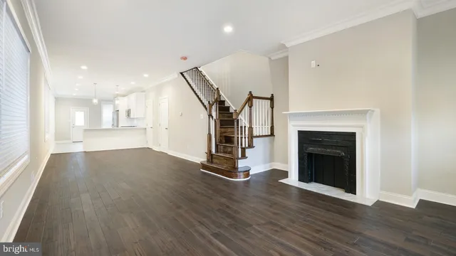 a view of a room with wooden floor fireplace and windows