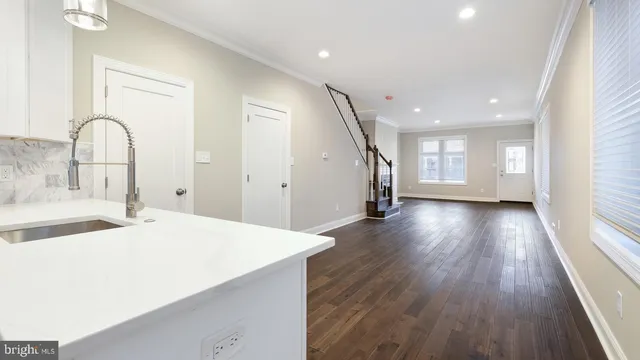 a kitchen with a wooden floor and natural light