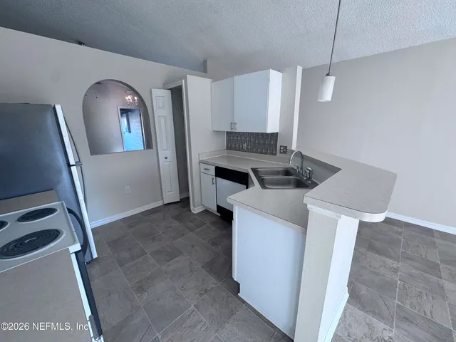 a kitchen with sink refrigerator and stove