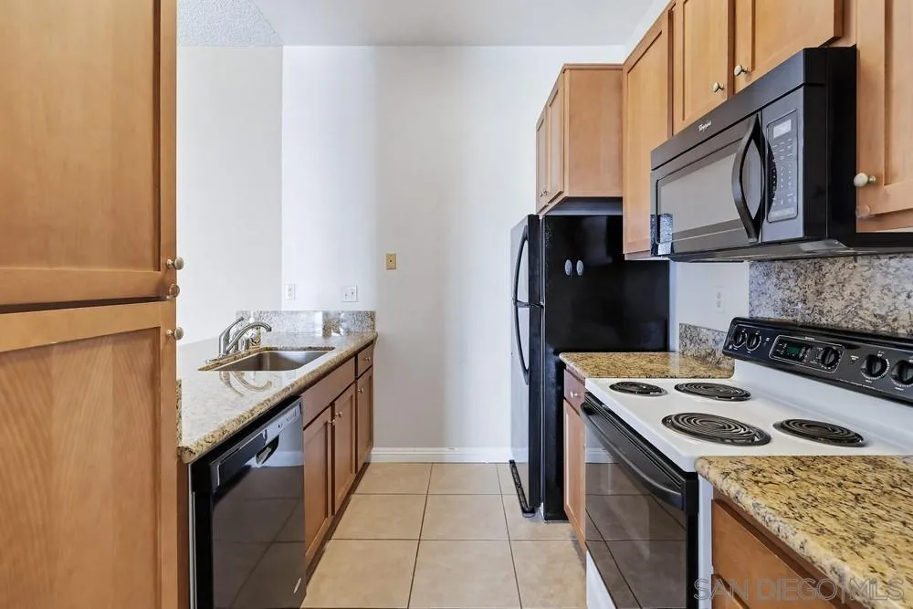 8324 Regents Road, Unit 2E San Diego, CA 92122 - Photo 10 of 31 a kitchen with granite countertop a sink stove and refrigerator