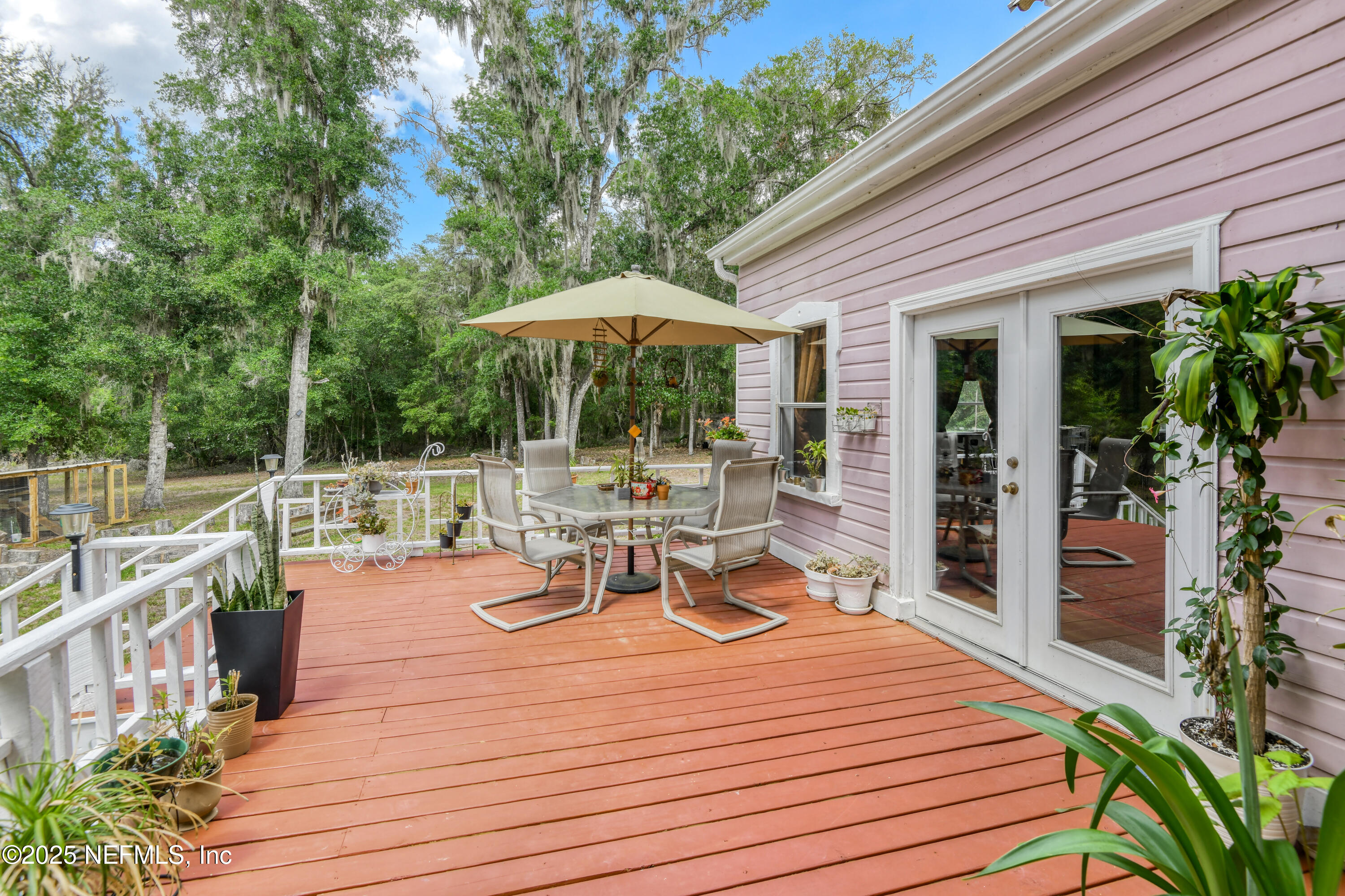 240 Sisco Road Pomona Park, FL 32181 - Photo 33 of 43 a view of a patio with table and chairs potted plants with wooden floor and fence