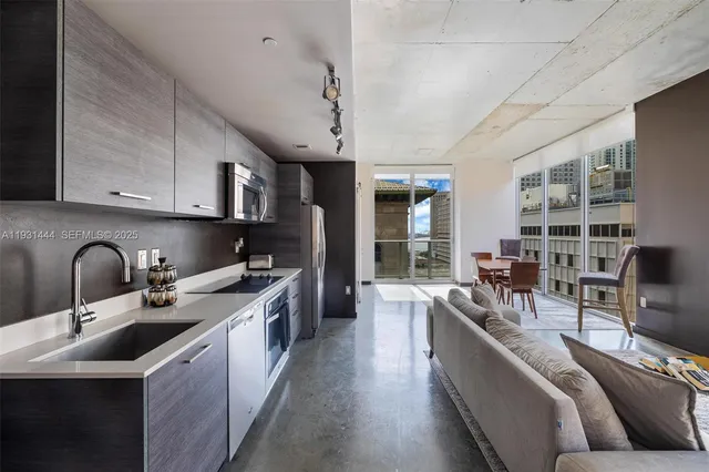 a kitchen with stainless steel appliances granite countertop a sink a stove and a refrigerator