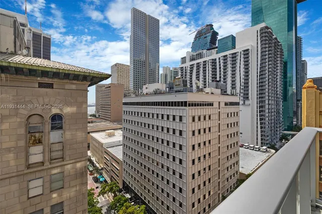 a view of a balcony with a couple of cars parked in front of house