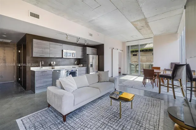 a living room with furniture and kitchen view
