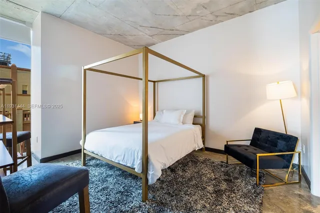 a bedroom with a bed and a potted plant on the dresser