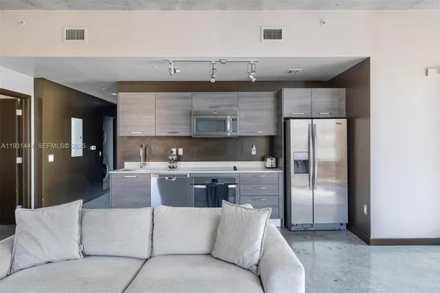 a kitchen with stainless steel appliances granite countertop a refrigerator and a stove