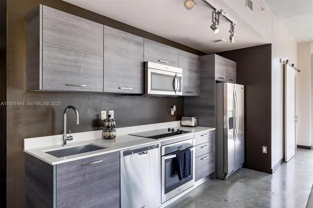 a kitchen with stainless steel appliances granite countertop a sink stove and refrigerator