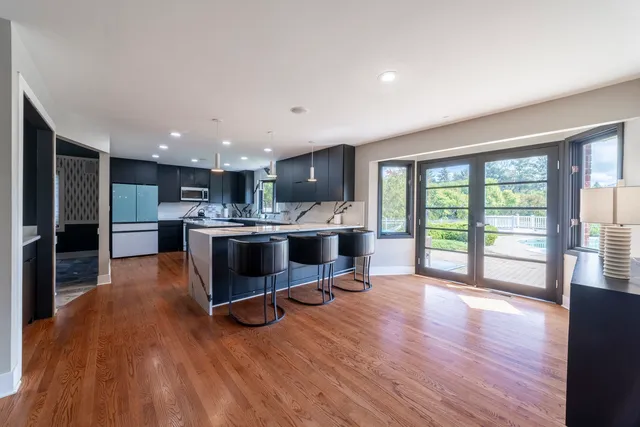 a kitchen with stainless steel appliances granite countertop a sink a stove and a refrigerator