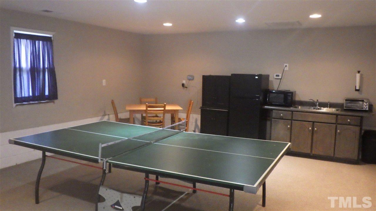 7434 Riley Hill Road Zebulon, NC 27597 - Photo 22 of 23 a kitchen with stainless steel appliances wooden floor dining table and chairs