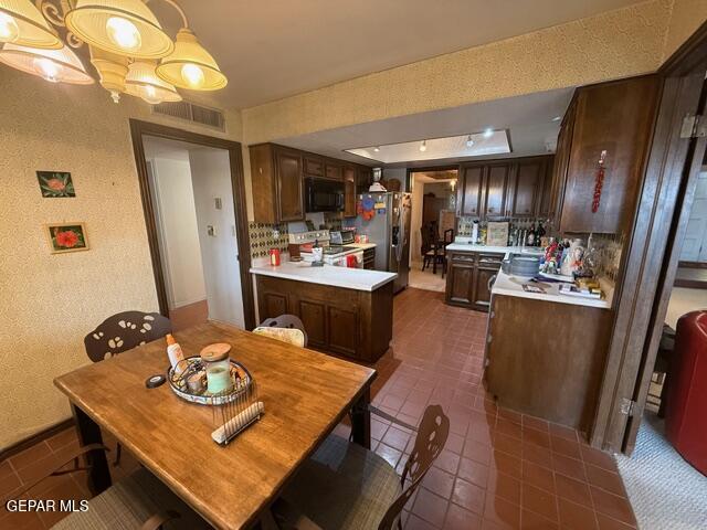 6435 Belton Road El Paso, TX 79912 - Photo 19 of 56 a view of a dining room with furniture a kitchen and chandelier