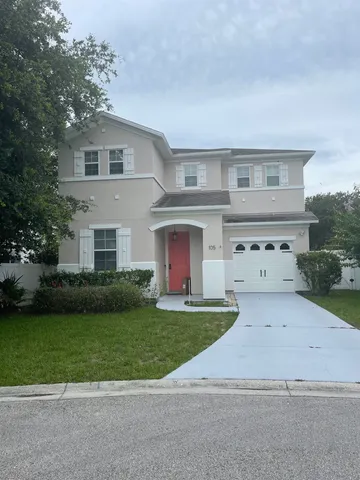 a front view of a house with a garden and yard