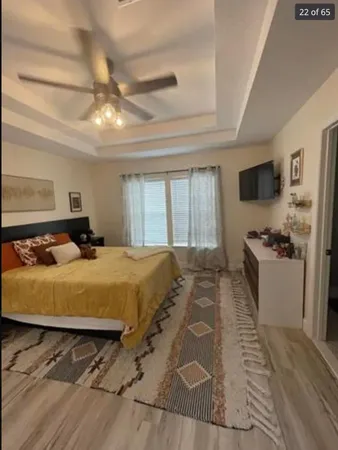 a bedroom with a large bed and a flat tv screen on dresser