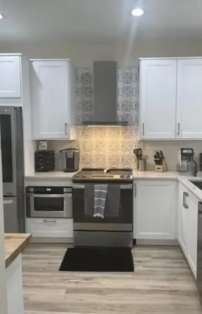 a kitchen with granite countertop wooden cabinets and stainless steel appliances