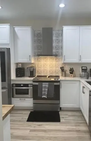a kitchen with granite countertop wooden cabinets and stainless steel appliances
