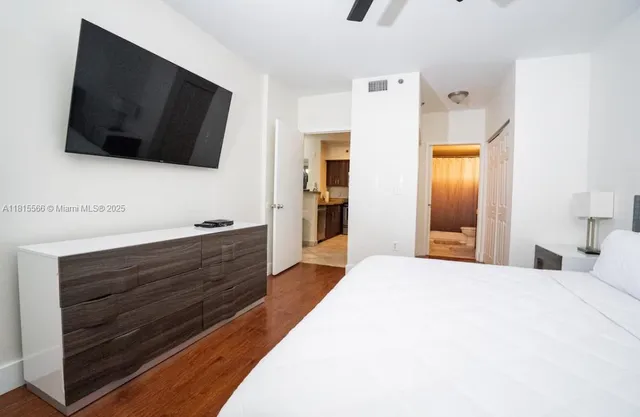 a spacious bedroom with a bed and a flat screen tv