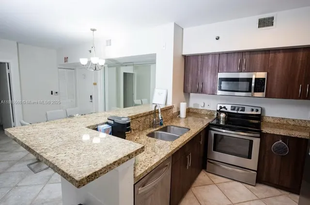 a kitchen with stainless steel appliances granite countertop a sink and a stove