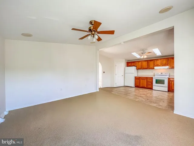 an empty room with a ceiling fan and window