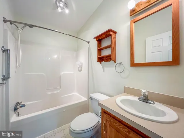 a view of a room with large mirror and cabinets