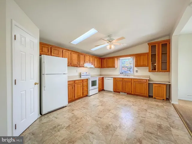 a kitchen with granite countertop stainless steel appliances white cabinets granite counter tops and a window