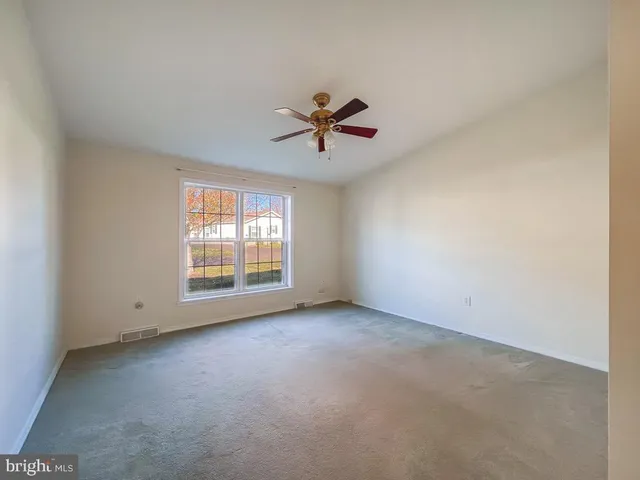 a view of a livingroom with a ceiling fan and window