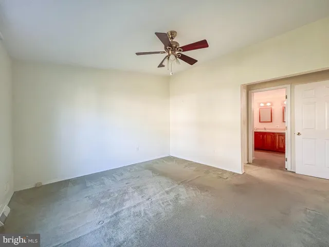 a view of a big room with a ceiling fan and a window