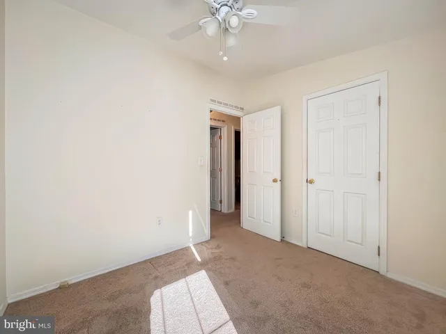 an empty room with a ceiling fan and a window
