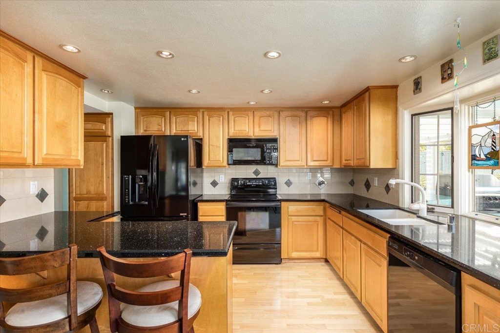 4040 Risa Circle San Diego, CA 92124 - Photo 14 of 43 a kitchen with a sink a counter top space stainless steel appliances and cabinets