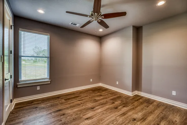 en empty room with window and a ceiling fan
