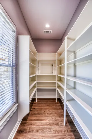 a view of walk in closet with empty racks