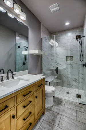 a bathroom with a granite countertop sink toilet and shower