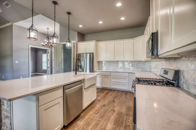 a kitchen with kitchen island granite countertop a sink and cabinets