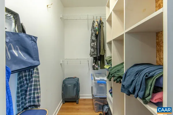 a view of walk in closet with clothes and shoes