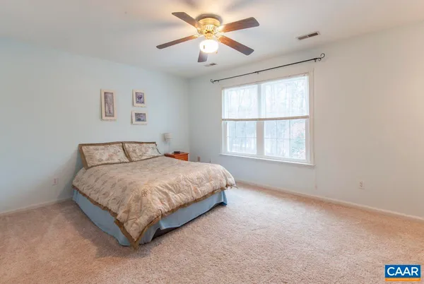 a spacious bedroom with a bed and a window