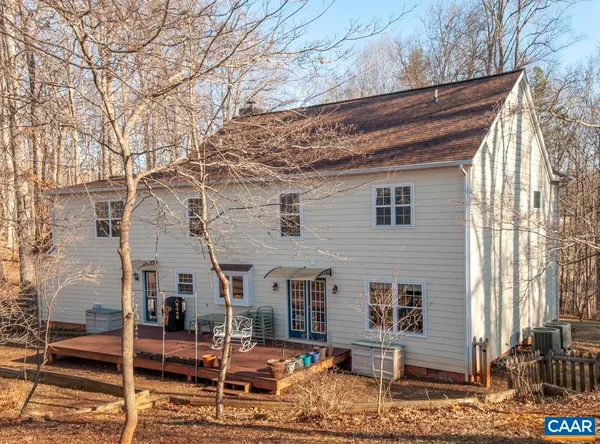 a backyard of a house with wooden fence and large trees