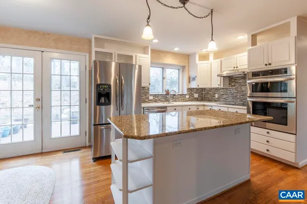 a kitchen with stainless steel appliances granite countertop a stove and a refrigerator