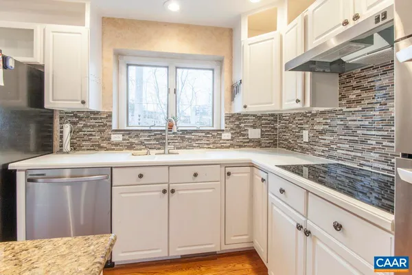 a kitchen with granite countertop a sink stove and cabinets