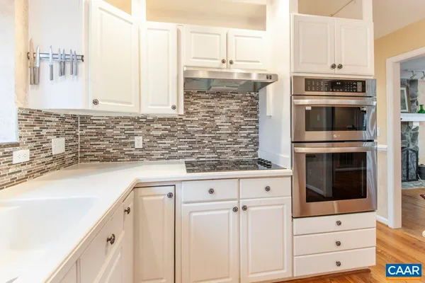 a kitchen with granite countertop white cabinets and stainless steel appliances