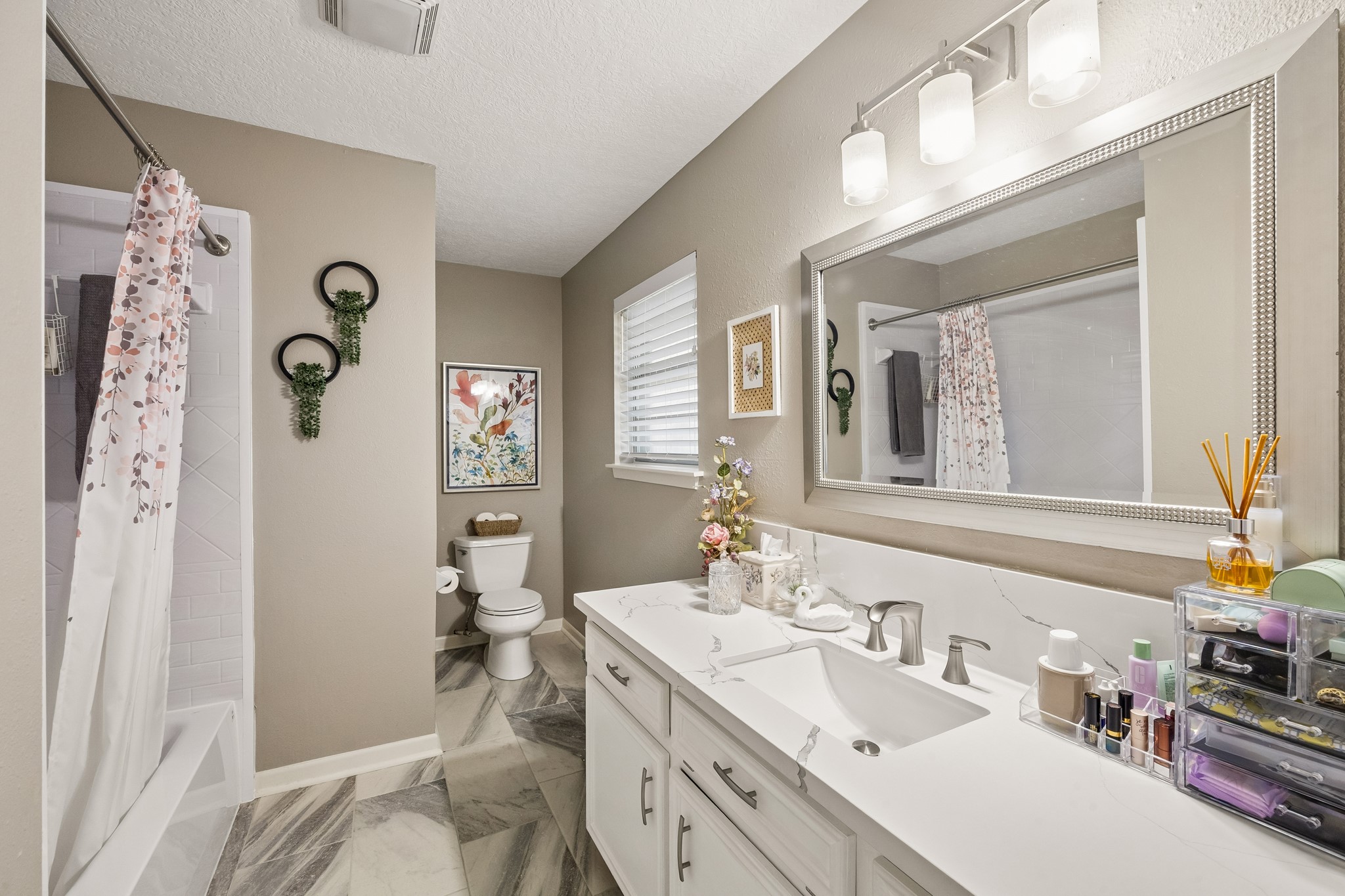 2102 Casa Rio Circle Dickinson, TX 77539 - Photo 12 of 22 Beautifully remodeled primary en-suite bathroom featuring a new granite vanity, updated lighting, and stylish finishes throughout. The Seller completely remodeled the tub and shower combo ~ new tub, tile and greenboard backing for added durability. A walk-in closet provides generous storage, making this private retreat both elegant and functional. ***Bonus ~ Seller had cabinetry resurfaced and repainted ~ upgraded the lighting fixtures and added a custom mirror***