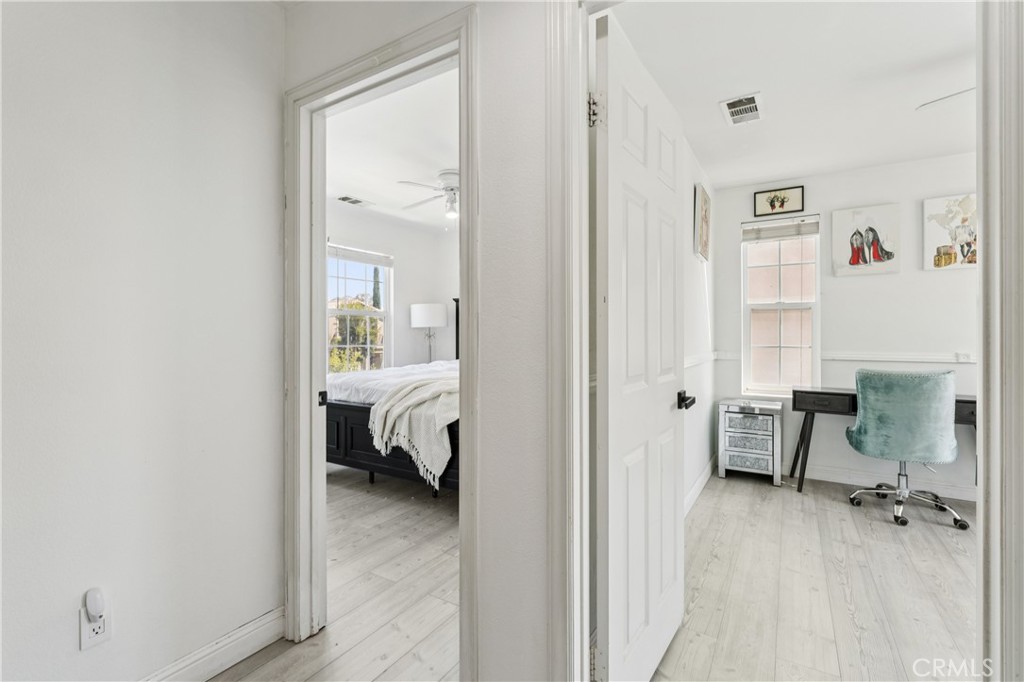 4155 Windspring Street Corona, CA 92883 - Photo 26 of 38 a view of a bedroom with a hardwood floor and a hallway