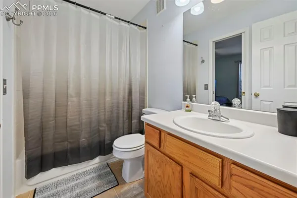 a bathroom with a sink a toilet a mirror and shower